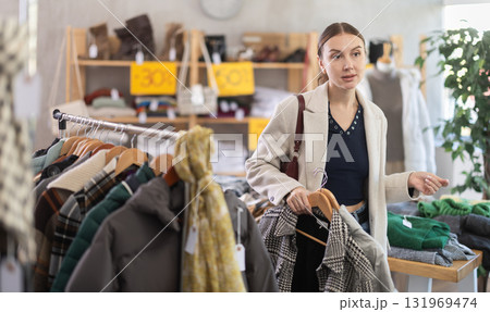 Woman choosing outerwear in a store Woman choosing outerwear in a store 131969474