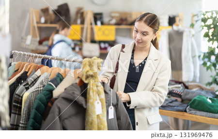 Elegance lady choose something for autumn-winter season in clothing boutique. Black Friday sale of winter clothing collection Elegance lady choose something for autumn-winter season in clothing boutique. Black Friday sale of winter clothing collection 131969476