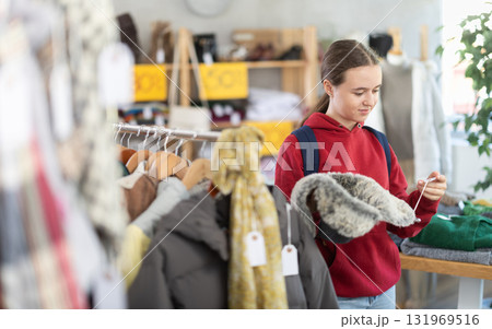 Teenage girl choosing a fur hat 131969516