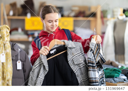 Teenage girl chooses coat in clothing store 131969647