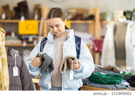 Teenage girl choosing a hat in the store Teenage girl choosing a hat in the store 131969802