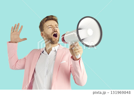 Portrait of excited young businessman screaming in megaphone Portrait of excited young businessman screaming in megaphone 131969848