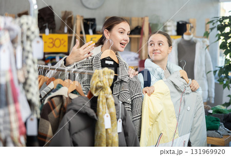 Adult woman and teenage girl choose outerwear 131969920