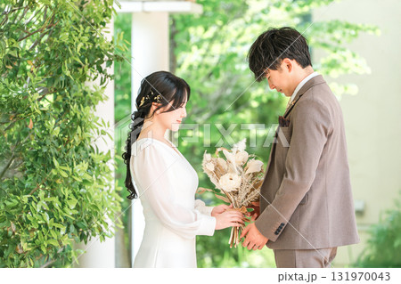 ブーケを持って見つめ合う新郎新婦(ウェディング・ブライダル・夫婦) ブーケを持って見つめ合う新郎新婦(ウェディング・ブライダル・夫婦) 131970043