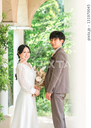 ブーケを持って見つめ合う新郎新婦(ウェディング・ブライダル・夫婦) 131970045