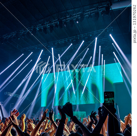 Performance at a rock concert, with people in front of the stage at a music festival. 131970262