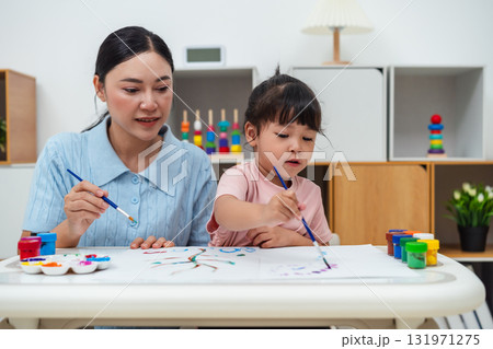 happy mother and toddler girl painting watercolor in paper at home 131971275