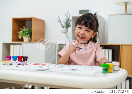 happy toddler girl painting watercolor in paper at home 131971278