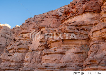 Visitors marvel at the rugged beauty of Tsvetnoy Canyons rock formations under a clear blue sky, revealing intricate layers and textures. Visitors marvel at the rugged beauty of Tsvetnoy Canyons rock formations under a clear blue sky, revealing intricate layers and textures. 131971620