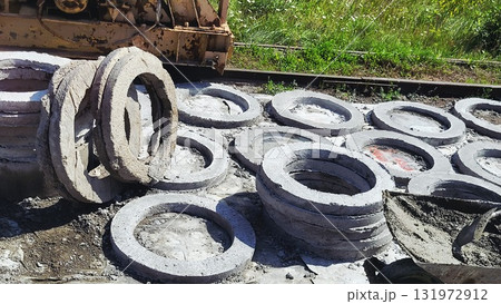 Construction of circular cement rings well structures near railway tracks for infrastructure development during daytime Construction of circular cement rings well structures near railway tracks for infrastructure development during daytime 131972912