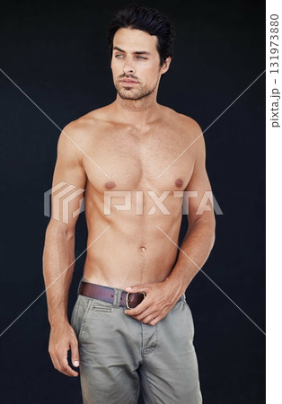 Model, man and muscle with tattoo on body in jeans for motivation with dark background. Male person, healthy and strong with sexy chest for training or shirtless after workout or exercise. 131973880