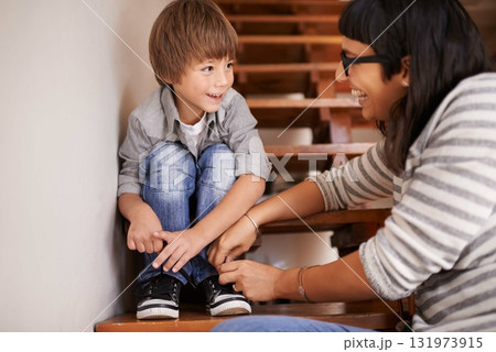 Learning, tying and shoes with mother and kid for child development, bonding and helping. Happy, smile and support with woman and young boy on steps in family home for laces, care and happiness Learning, tying and shoes with mother and kid for child development, bonding and helping. Happy, smile and support with woman and young boy on steps in family home for laces, care and happiness 131973915