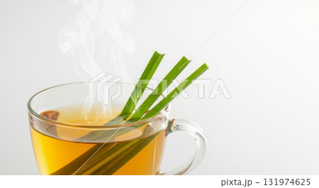Hot lemongrass tea in a clear glass cup with fresh herbs. Steaming herbal infusion for wellness and detox on a white background with copy space Hot lemongrass tea in a clear glass cup with fresh herbs. Steaming herbal infusion for wellness and detox on a white background with copy space 131974625