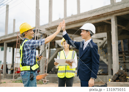 Engineer desk with object paper and tablet with blurry engineer teamwork hardworking to consults about their building Engineer desk with object paper and tablet with blurry engineer teamwork hardworking to consults about their building 131975031