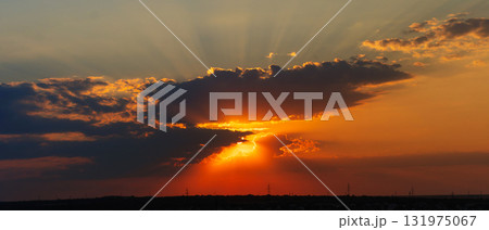 Radiant sunset with golden sun rays breaking through dark clouds Radiant sunset with golden sun rays breaking through dark clouds 131975067