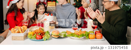 Happy Asian family celebrating Christmas together at home. Real people wearing Santa hats, exchanging gifts, smiling with joy, festive dinner, love, and holiday cheer. Happy Asian family celebrating Christmas together at home. Real people wearing Santa hats, exchanging gifts, smiling with joy, festive dinner, love, and holiday cheer. 131975458