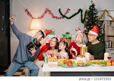 Celebrate Christmas with family in a cozy, festive setting filled with gifts, love, and joy. 131975503