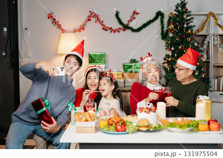 Celebrate Christmas with family in a cozy, festive setting filled with gifts, love, and joy. 131975504