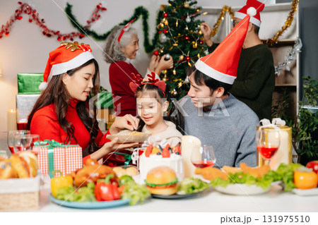 Celebrate Christmas with family in a cozy, festive setting filled with gifts, love, and joy. 131975510