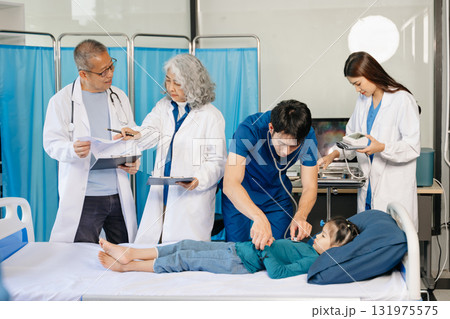 Group of Asian doctors and nurses consulting a young child patient in hospital ward. Real people, teamwork, pediatric care, diagnosis, and professional healthcare service. 131975575