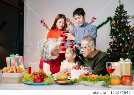 Celebrate Christmas with family in a cozy, festive setting filled with gifts, love, and joy. 131975643