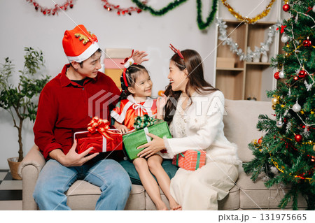 Celebrate Christmas with family in a cozy, festive setting filled with gifts, love, and joy. 131975665
