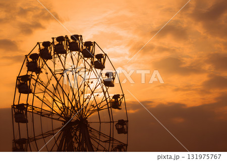 夕焼け空に浮かぶ観覧車のシルエット。ノスタルジックでロマンチックな風景 131975767