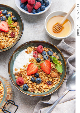 Granola bowls with berries, yogurt, nuts, and honey for breakfast Granola bowls with berries, yogurt, nuts, and honey for breakfast 131976034