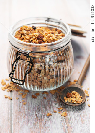 Granola breakfast cereal in glass jar with spoon Granola breakfast cereal in glass jar with spoon 131976038