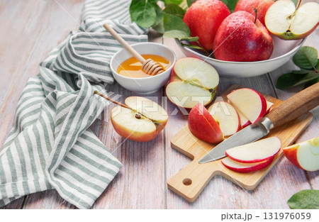 Sliced red apples and honey on wooden table 131976059