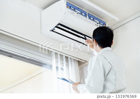エアコンを点検する作業員の男性 131976369