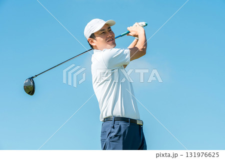 ゴルフ場でドライバーを振るゴルファーの男性(青空) 131976625