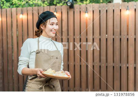 おしゃれなカフェで働くエプロン姿の若いアジア人女性 おしゃれなカフェで働くエプロン姿の若いアジア人女性 131978856