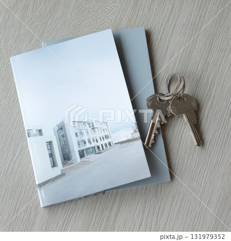 Overhead View of Apartment or Real Estate Brochure with Modern Building Image and a Set of New Silver Keys Resting on a Clean Wood Desk, Symbolizing Property Investment and Home Ownership Overhead View of Apartment or Real Estate Brochure with Modern Building Image and a Set of New Silver Keys Resting on a Clean Wood Desk, Symbolizing Property Investment and Home Ownership 131979352