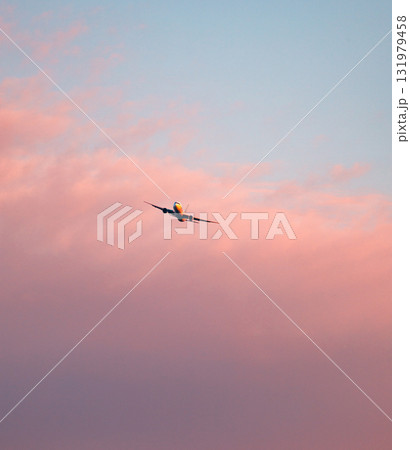 夕暮れの赤く染まった空とこれから着陸する飛行機 131979458
