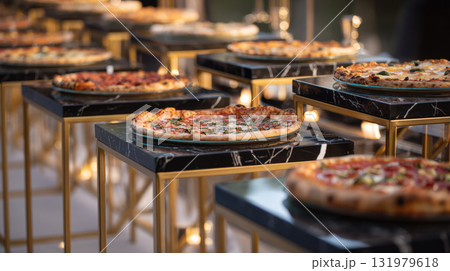 Upscale catering display of multiple gourmet pizzas served on individual glass plates, resting on modern, multi-level stands with black marble tops, gold metal frames, perfect for wedding 131979618