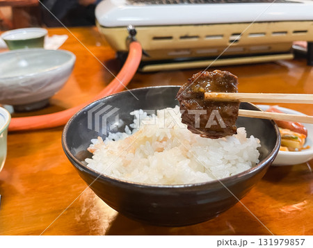 焼いたお肉を味噌タレに付けてご飯と一緒に食べる。焼肉屋の風景。 焼いたお肉を味噌タレに付けてご飯と一緒に食べる。焼肉屋の風景。 131979857