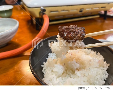 焼いたお肉を味噌タレに付けてご飯と一緒に食べる。焼肉屋の風景。 焼いたお肉を味噌タレに付けてご飯と一緒に食べる。焼肉屋の風景。 131979860