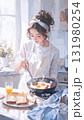 柔らかな朝日が差し込むキッチンで料理をする女性 131980254