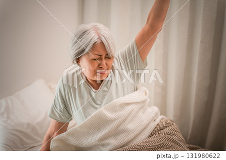 ベッドルームで寝起きに苦しい表情をするグレイヘアーのシニア女性 131980622