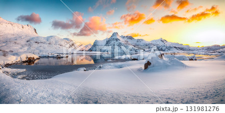 Amazing Flakstadpollen and Boosen fjords with cracks on ice during sunrise with Hustinden mountain on background. 131981276