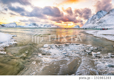 Stunning winter scenery with Haukland beach during sunset and snowy mountain peaks near Leknes. Stunning winter scenery with Haukland beach during sunset and snowy mountain peaks near Leknes. 131981283