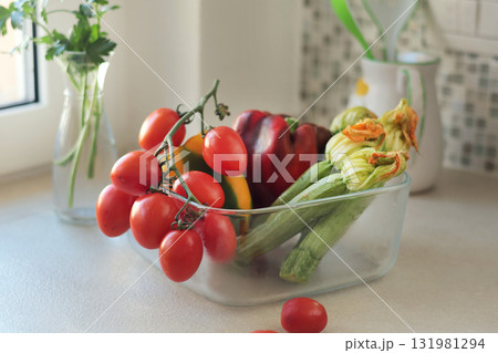 Fresh vegetables in glass bowl in kitchen. Mosaic tiles on wall in Italy. Eco-friendly farm products and healthy eating, longevity. Mediterranean cuisine. 131981294
