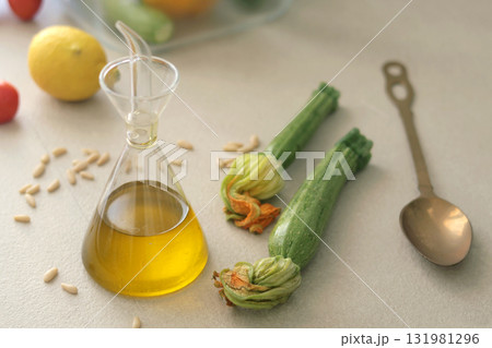 Fresh vegetables and olive oil in glass bottle in kitchen. Eco-friendly farm products and healthy eating, longevity. Mediterranean cuisine. 131981296