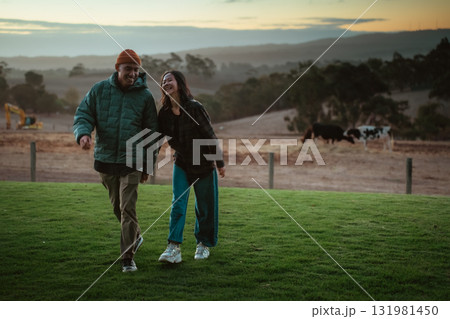Joyful Couple Walking Together in a Scenic Outdoor Setting at Sunset 131981450