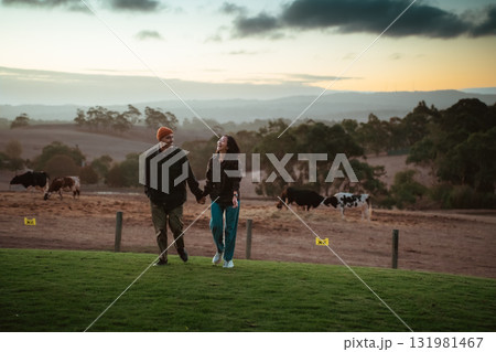 A Couple Enjoys a Delightful and Romantic Stroll on a Farm at Sunset 131981467