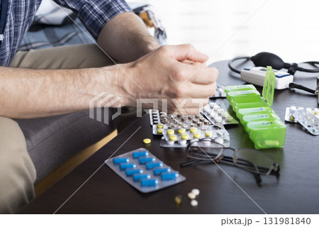 Middle aged caucasian man going to take pills from pillbox 131981840