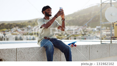 Black man, selfie on rooftop and social media post, memory while at skate park with app and happy outdoor. Influencer, content creation and smile in picture with cityscape, trendy skater and travel 131982102