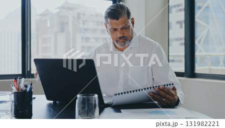 Laptop, office and business man with documents for financial report, data analysis and research. Corporate, computer and worker reading paperwork for finance, accounting and company savings review 131982221