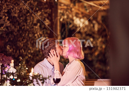 Love, kiss and garden with couple in restaurant for date, romance or affectionate in outdoors. Celebration, anniversary and valentines day with man and woman flirt in passionate bonding at dinner Love, kiss and garden with couple in restaurant for date, romance or affectionate in outdoors. Celebration, anniversary and valentines day with man and woman flirt in passionate bonding at dinner 131982371